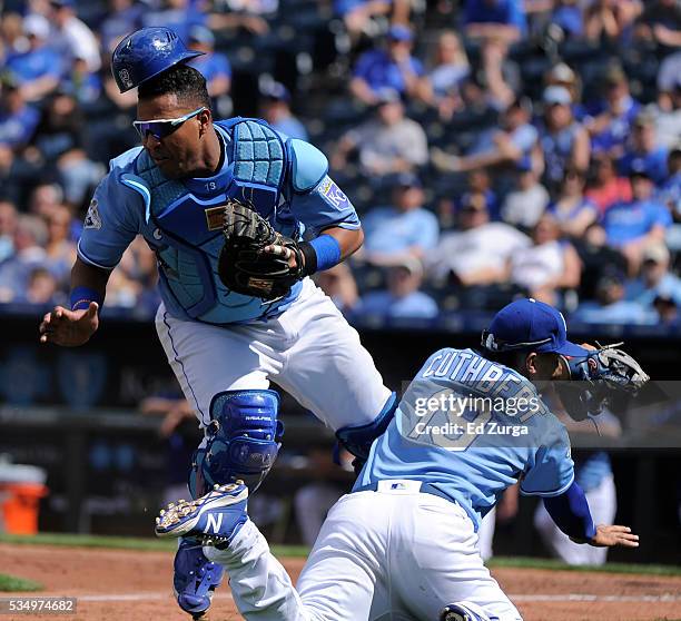Salvador Perez of the Kansas City Royals catches a foul ball hit by Adam Eaton of the Chicago White Sox as he collides into Cheslor Cuthbert in the...