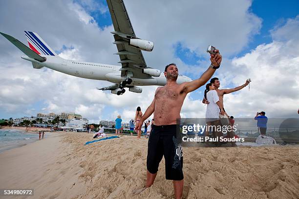 tourists and landing jet at st. maarten, netherlands antilles - air france stock pictures, royalty-free photos & images