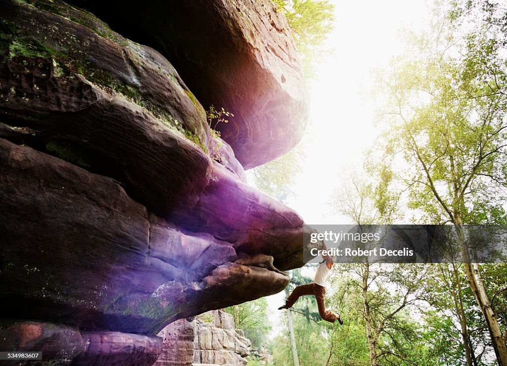 Female free climber hanging from rock