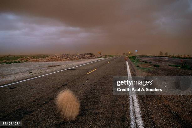 storm clouds above highway in new mexico - tumble weed stock pictures, royalty-free photos & images