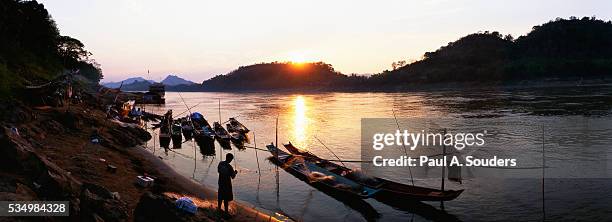 fishers with canoes on mekong river - mekong delta stock pictures, royalty-free photos & images