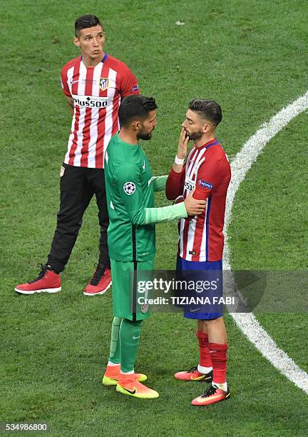 Atletico Madrid's Spanish goalkeeper Miguel Angel Moya consols Atletico Madrid's Belgian forward Yannick Ferreira Carrasco after loosing to Real...
