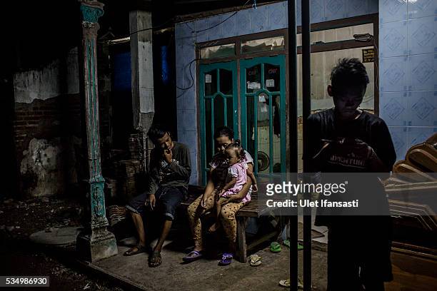Family sits in front their house which was affected by mudflow in Merisen Village on May 27, 2016 in Sidoarjo, East Java, Indonesia. The Merisen...