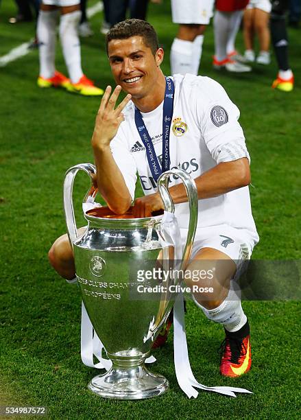 Cristiano Ronaldo of Real Madrid celebrates with the Champions League Trophy and gestures that it is his third time winning it after the UEFA...