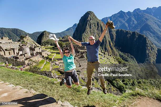 hikers leap to celebrate at machu picchu, peru - machu pichu stock pictures, royalty-free photos & images