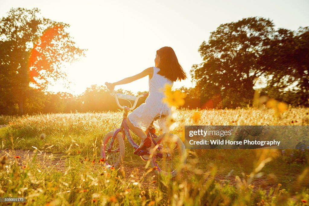 Girl riding bike in the sunset