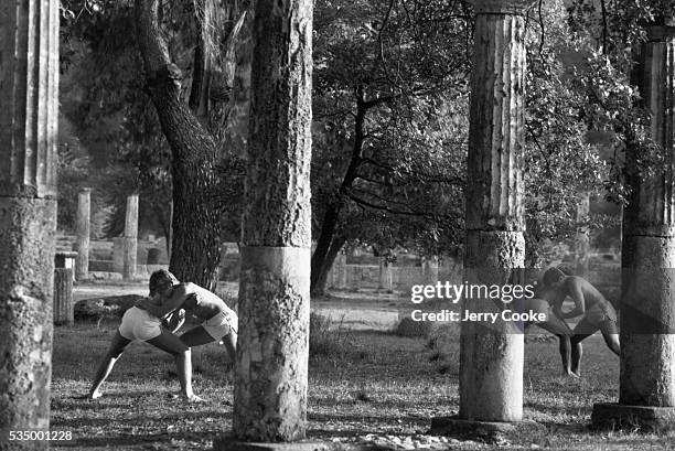 High school boys wrestle within the ruins of a site where the ancient Olympic games were held.