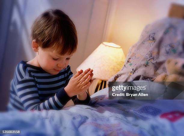 boy praying before going to bed - child praying stock pictures, royalty-free photos & images