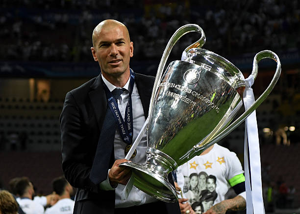 Real Madrid head coach Zinedine Zidane shows the trophy after winning the UEFA Champions League Final match between Real Madrid and Club Atletico de...