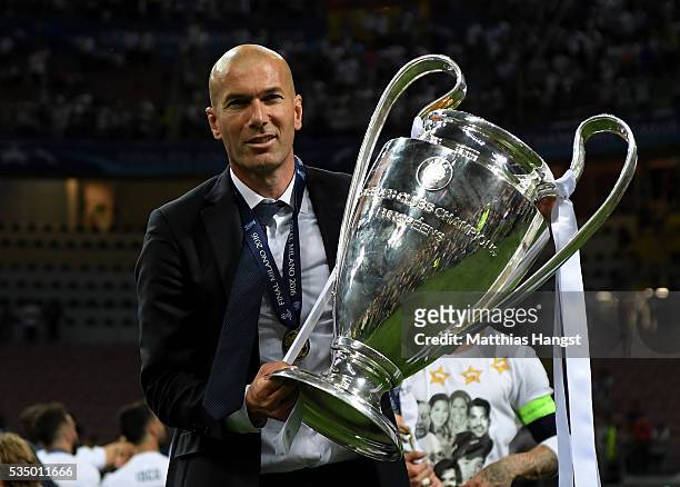 Real Madrid head coach Zinedine Zidane shows the trophy after winning the UEFA Champions League Final match between Real Madrid and Club Atletico de...