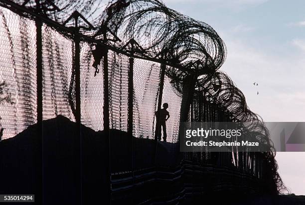 children playing near barbed wire border fence - wire mesh fence stock-fotos und bilder