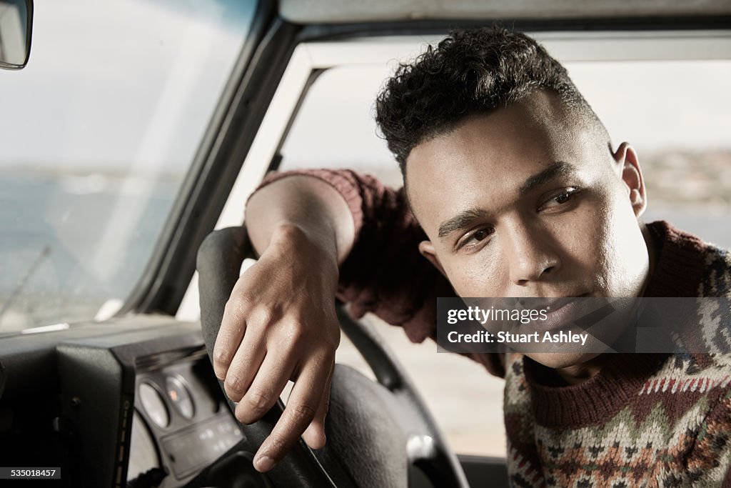 Male on coastal road, sitting in car