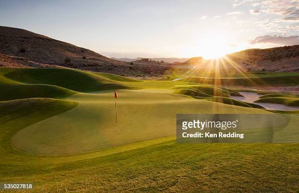 putting green at sunset - golf stock-fotos und bilder