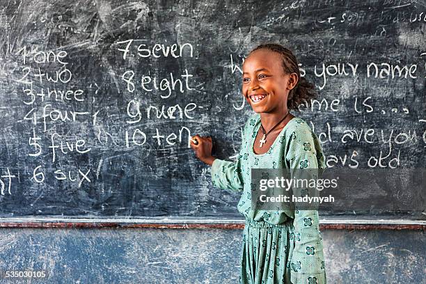 african little girl is learning english language - african school kids stockfoto's en -beelden