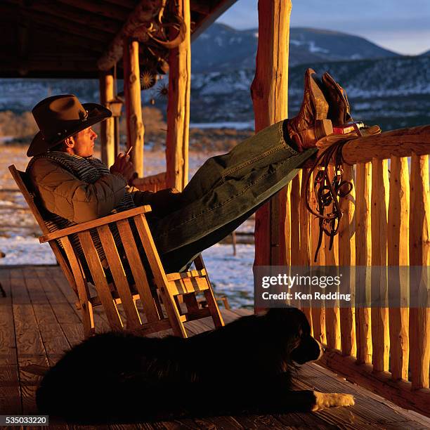 cowboy on front porch in rocking chair - rocking chair stock pictures, royalty-free photos & images