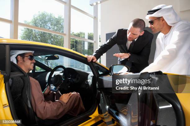 man sitting in car talking with car dealer - persian gulf countries stock pictures, royalty-free photos & images