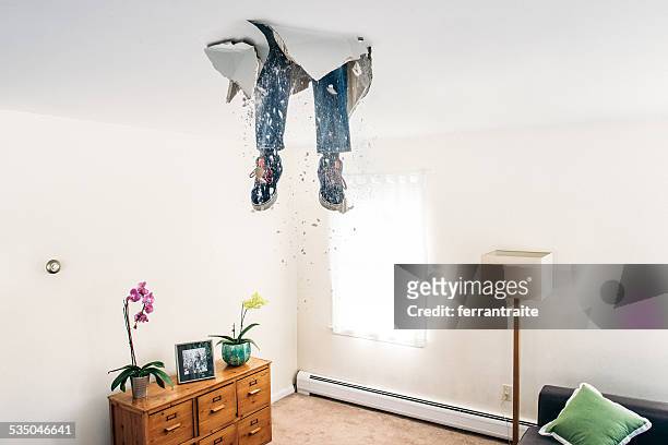 man breaks ceiling drywall while doing diy - humor stockfoto's en -beelden