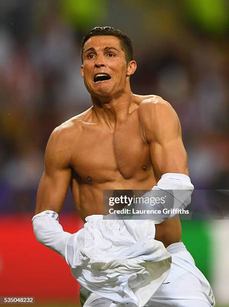 Cristiano Ronaldo of Real Madrid takes off his shirt in celebration after scoring the winning penalty in the penalty shoot out during the UEFA...