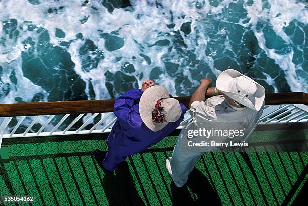 Elderly couple enjoying a walk on deck of the coastal express. For some it is a way of travelling along the coast of Norway but for many tourists,...