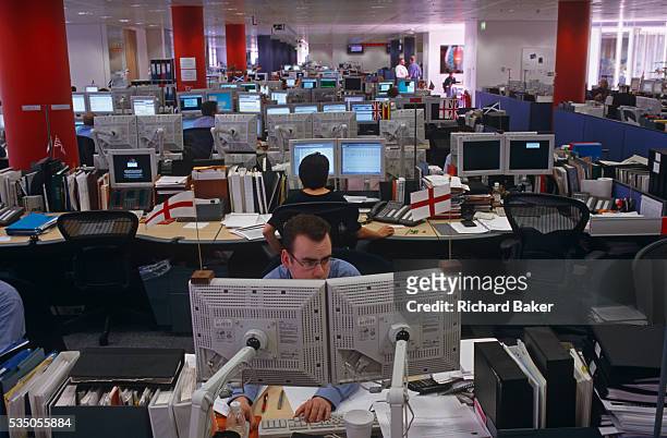 An analyst for the Enron Corporation, the American energy company based in Houston, Texas, stares transfixed into two computer monitors in the London...