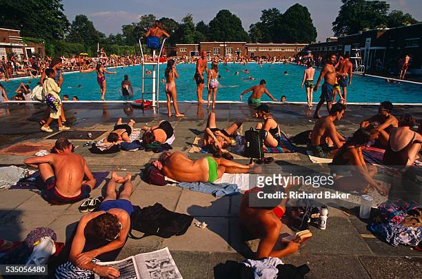 During an August heatwave, the population of Brixton and many others from all over London, bask in the glorious weather at the Brockwell Lido in...