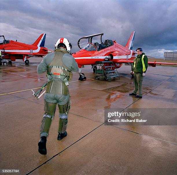 Squadron Leader Duncan Mason of the elite 'Red Arrows', Britain's prestigious Royal Air Force aerobatic team, strides out across a gloomy, rainswept...