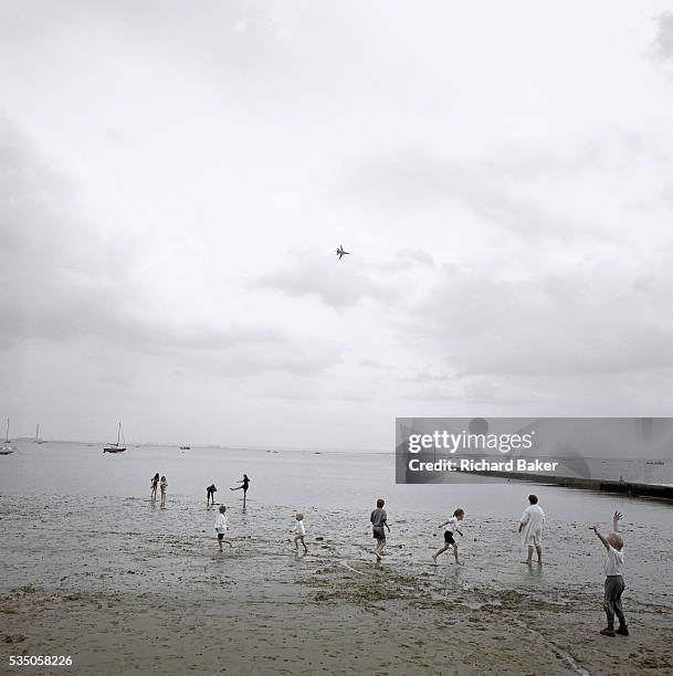 Lone Tornado jet fighter arcs across a typically overcast sky at Southend-on-Sea on a Bank Holiday Sunday. Well-defined figures of children and...