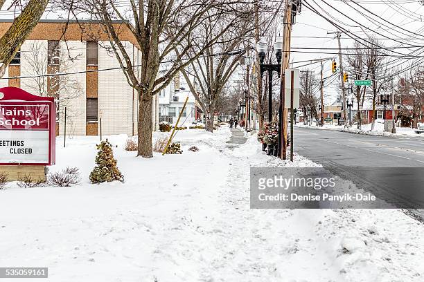 School's closed. Pedestrians walk on sidewalk toward school closed due to snow. Morris Plains, NJ. January 27, 2015