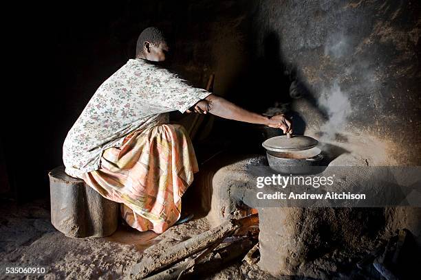 Madam Betty Okiru cooking in a hut using a fuel-efficient stove. The stove is constructed in a way that uses the least amount of wood, a chimney is...