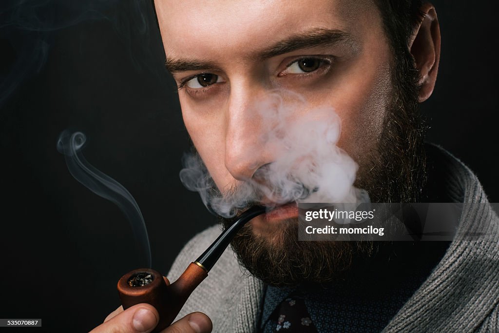 Young man smoking a pipe