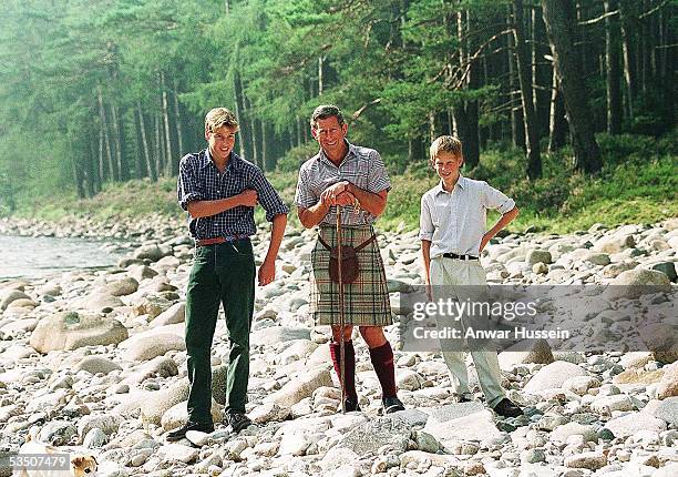 Charles, Prince of Wales, Prince William and Prince Harry pose for photographs on the banks of the River Dee while on holiday on August 12, 1997 in...