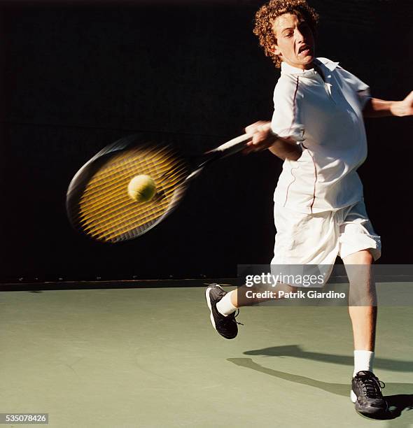 young male tennis player hitting forehand - tennisball stock-fotos und bilder