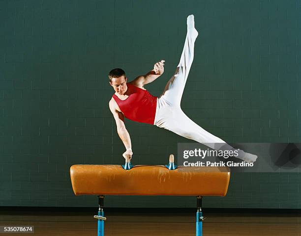 gymnast performing on pommel horse - male gymnast stockfoto's en -beelden