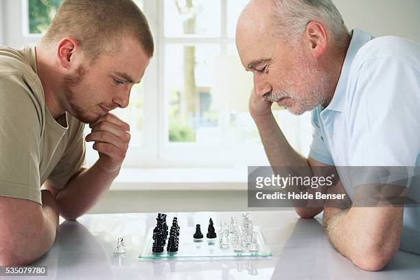 father and son playing chess - chess championship stock pictures, royalty-free photos & images