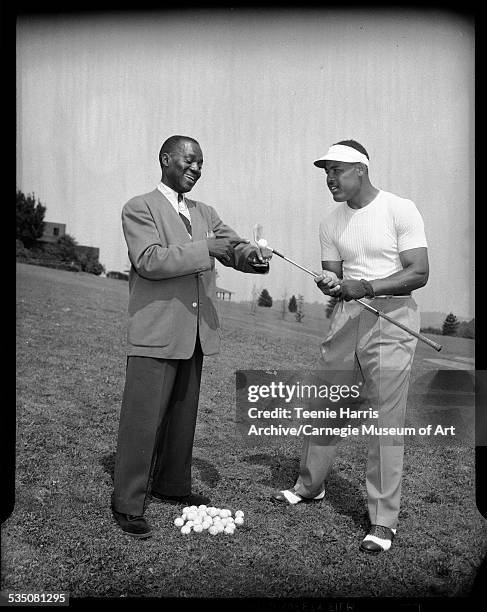 Bill 'Bojangles' Robinson and Joe Louis with golf club at South Park golf course for Tournament of Champions tournament, Pittsburgh, Pennsylvania,...