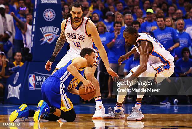 Stephen Curry of the Golden State Warriors handles the ball as Steven Adams of the Oklahoma City Thunder and Kevin Durant react during the first half...