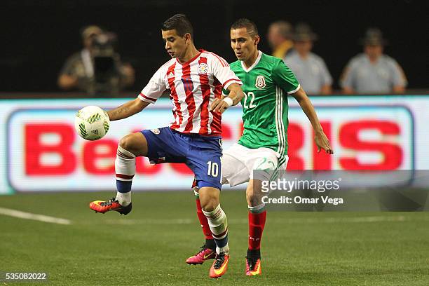 Derlis Gonzalez of Paraguay is challenged by Paul Aguilar of Mexico during the International Friendly between Mexico and Paraguay at Georgia Dome on...