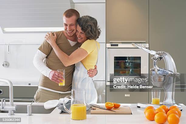 mother and son hugging in kitchen - huis ter heide stockfoto's en -beelden