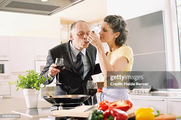 a man sampling his wife's cooking - stir frying european stock pictures, royalty-free photos & images