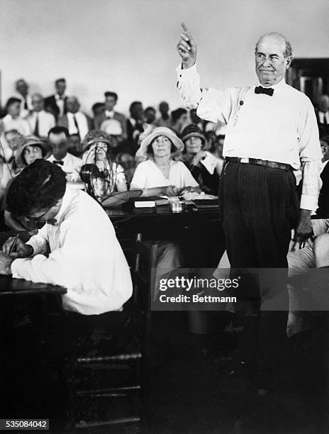 William J. Bryan makes his first speech during the Scopes trial. He is shown full-length, raising his hand in a pointing gesture.