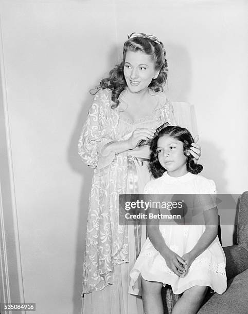 Hollywood, CA- Whipping out a comb for a fast repair job, Mama Joan Fontaine pretties daughter Martita before introducing her to the rest of the cast...