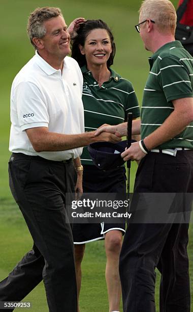 Colin Montgomerie shakes hands with Chris Evans while celebrity golfer Catherine Zeta-Jones looks on, on the final day of The All-Star Cup Celebrity...