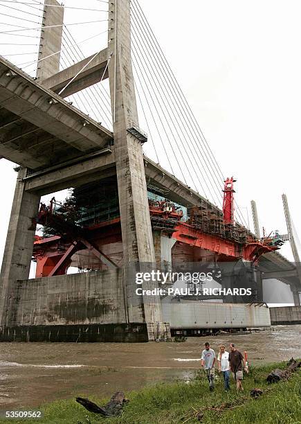 Mobile, UNITED STATES: Towboat and shipyard workers John and Michelle Welborn walk with Robert Rishel away from the Mobile Bay after an oil rig tore...