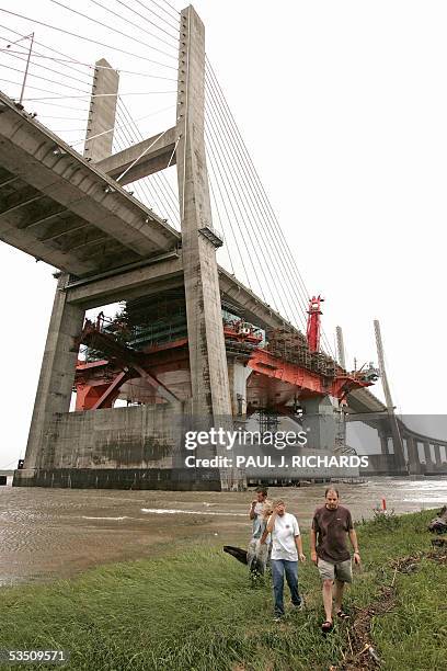 Mobile, UNITED STATES: Towboat and shipyard workers John and Michelle Welborn walk with Robert Rishel away from the Mobile Bay after an oil rig tore...