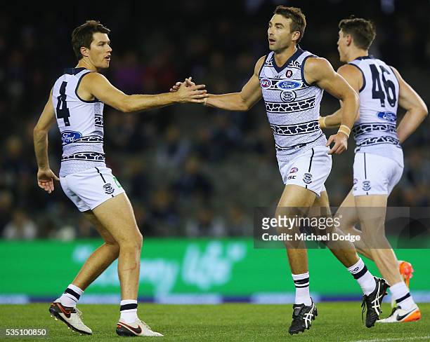Corey Enright of the Cats celebrates a goal with Andrew Mackie during the round 10 AFL match between the Carlton Blues and the Geelong Cats at Etihad...