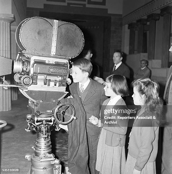 Italian director Roberto Rossellini showing a movie camera to his children Robertino, Isotta and Isabella. Italy, 1957