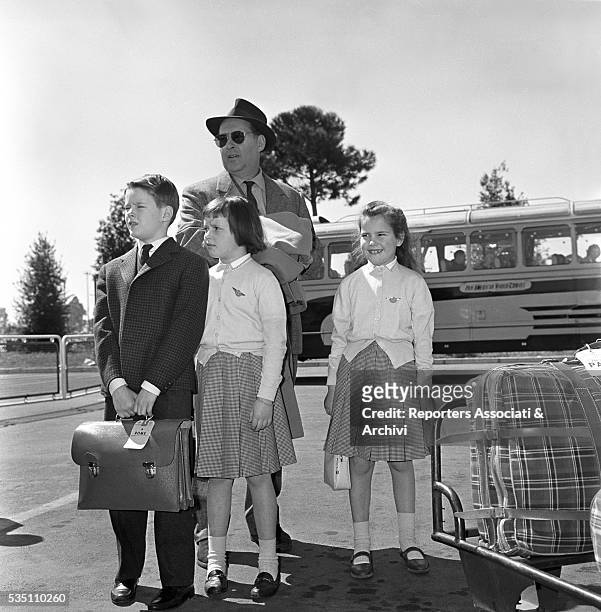 Italian director Roberto Rossellini posing with his children Robertino, Isotta and Isabella at the airport. Italy, 14th April 1960