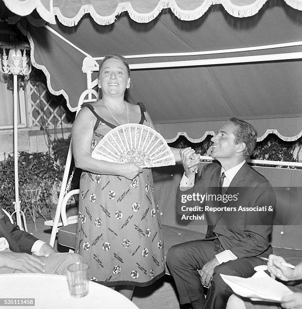 Italian actor Rossano Brazzi and his wife Lidia Bertolini hand in hand during an evening on their terrace. 21st August 1965