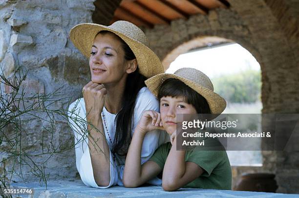 Italian ballet dancer Carla Fracci and her son Francesco wearing straw hats. 1978
