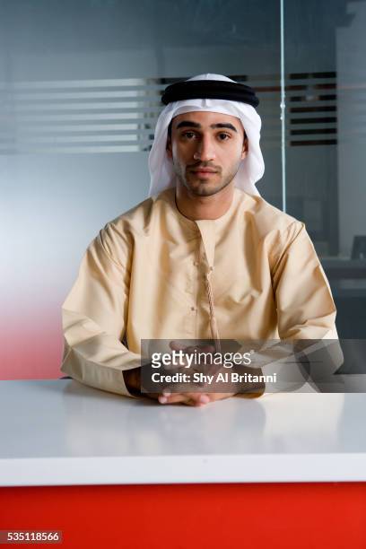profile of an emirati man at his desk. - emirati man portrait stockfoto's en -beelden